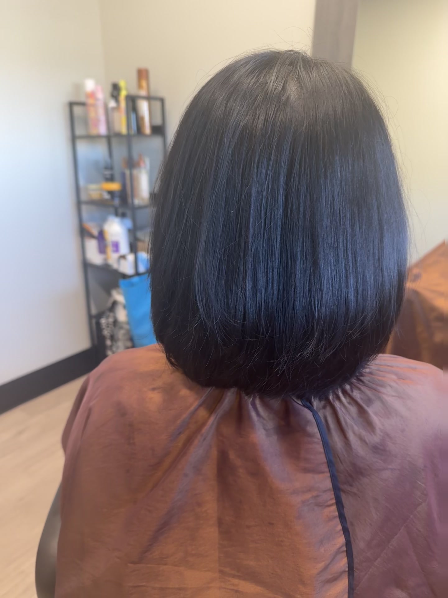 Back view of a chin-to-shoulder length dark bob with smooth, rounded ends.