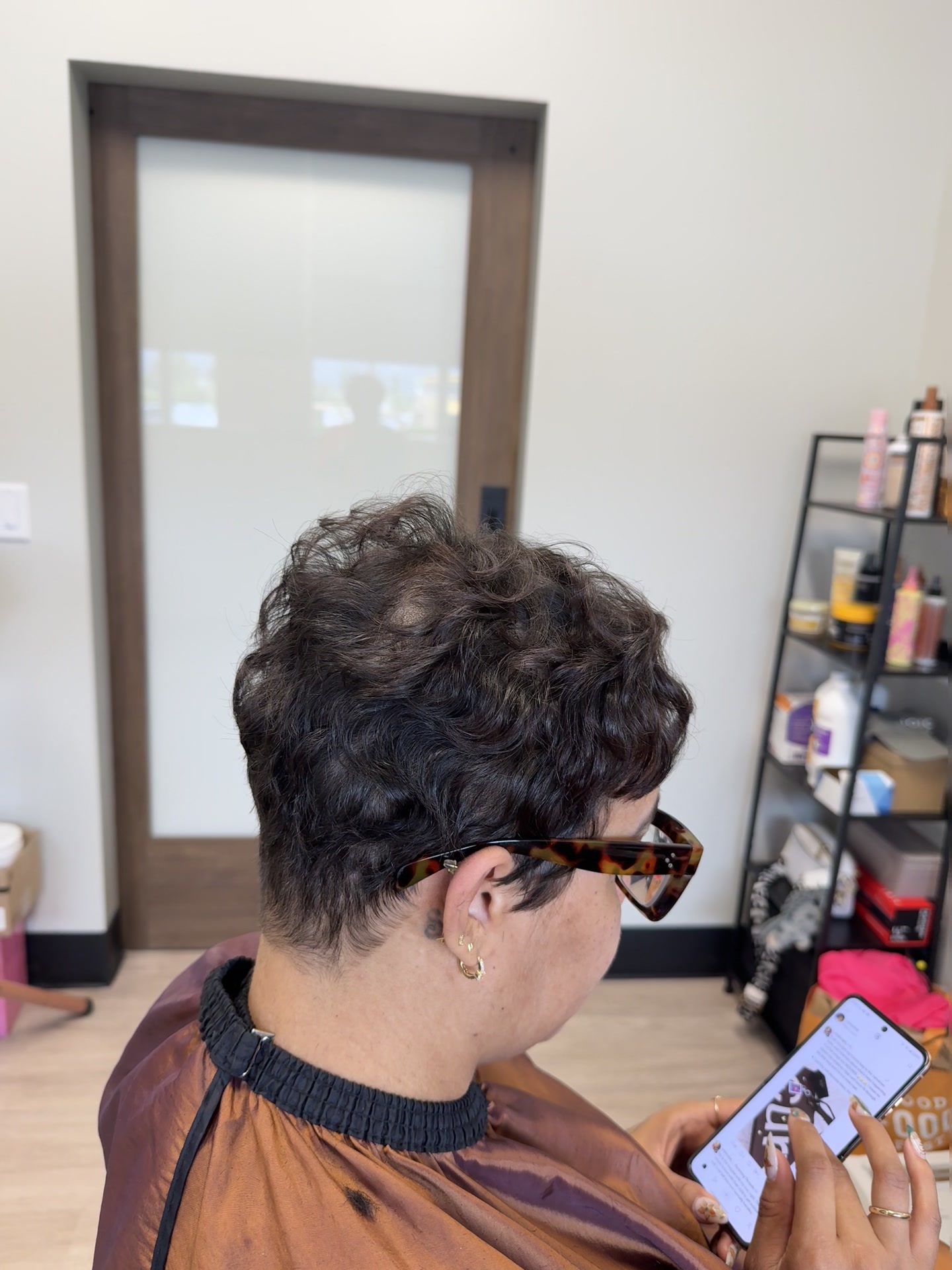 Side view of a short textured cut with soft waves shaped around the ear and nape.